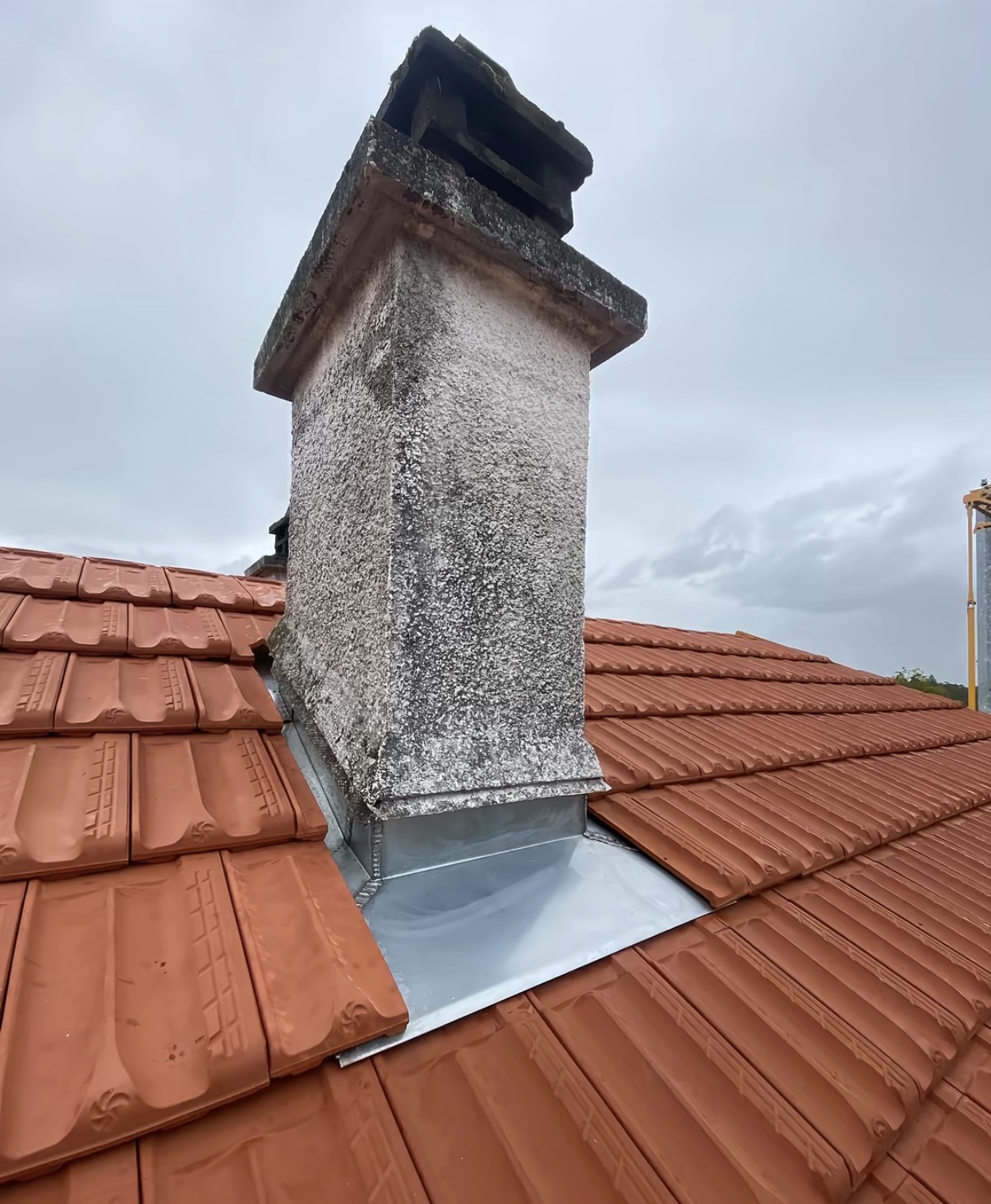 Abergement de cheminée en zinc façonné sur toiture en tuile
